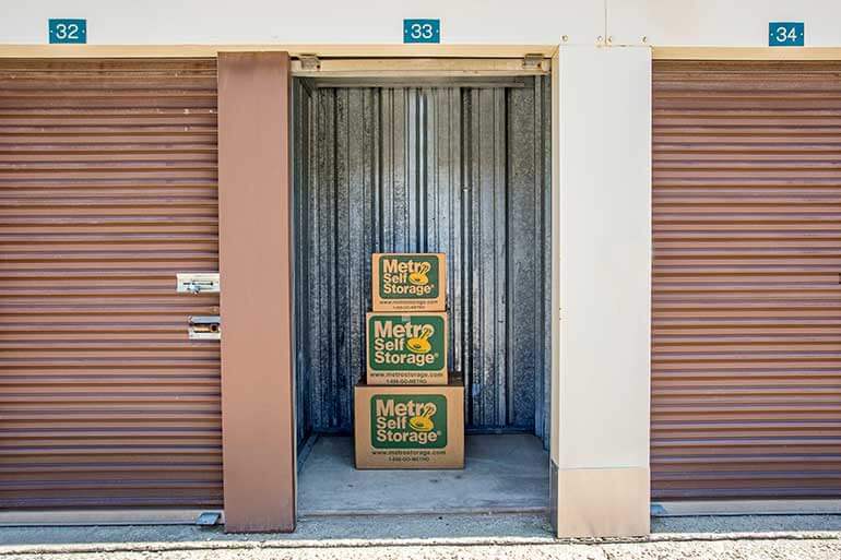 Metro Self Storage branded moving boxes stacked inside 5X5 storage unit