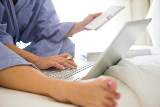 Woman using laptop to make list of what to downsize