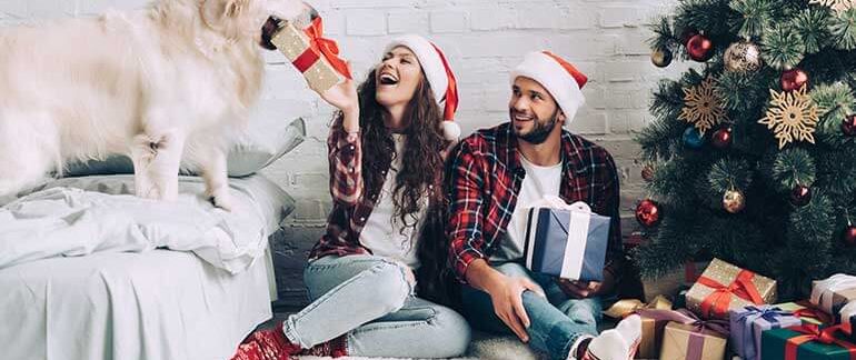 A family hands their pet a wrapped present to unwrap