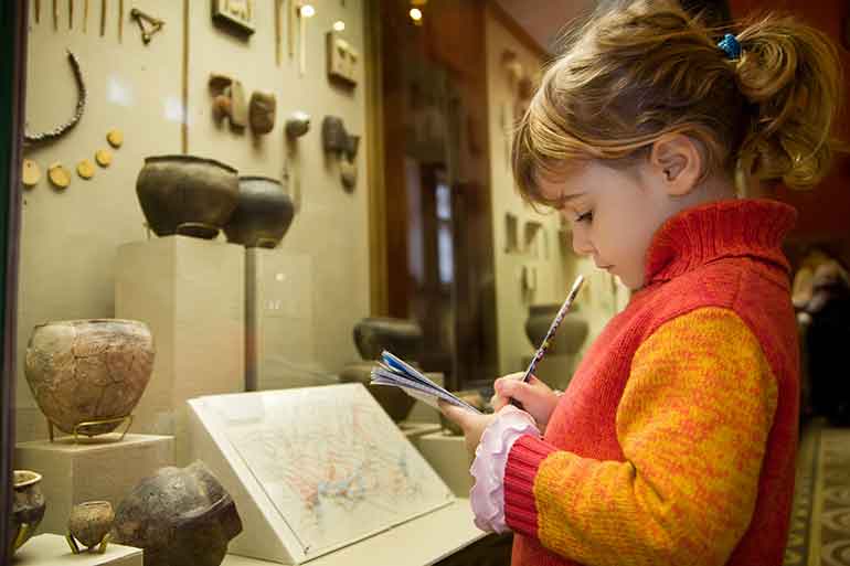 little girl writing at the Museum of Science and Industry in a South Side Chicago Neighborhood