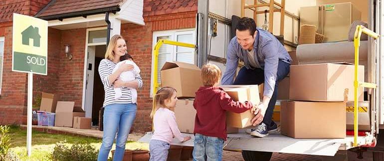 A family around a moving truck full of boxes.