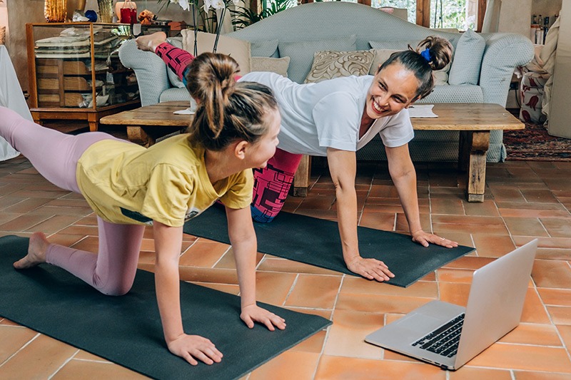mother and daughter doing yoga at home
