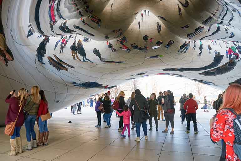 Millenials walking under The Bean in Chicago