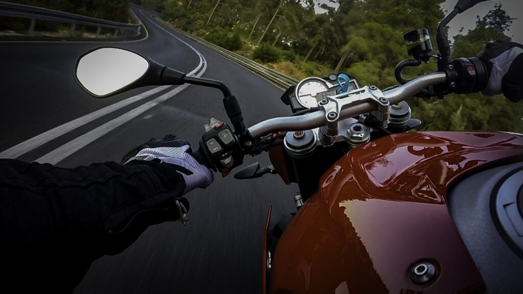 POV of motorcyclist driving down a winding highway.