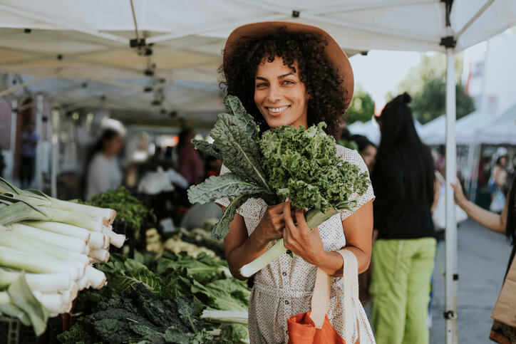 Young woman holding produce at the farmer's market. 