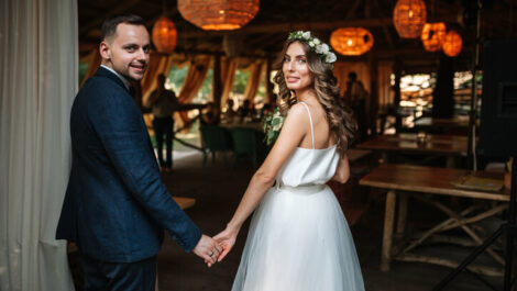 Couple holding hands at wedding reception.