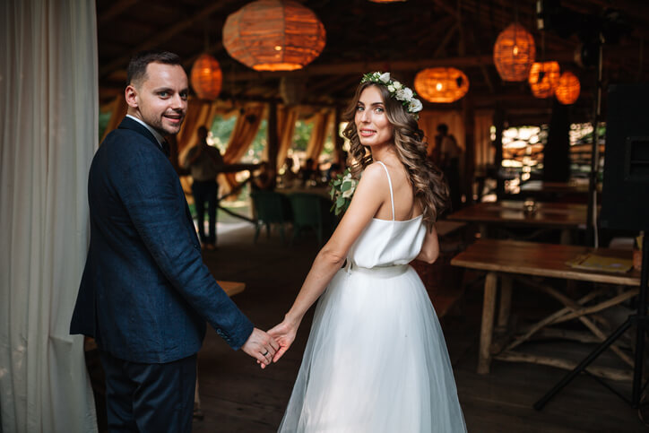 Couple holding hands at wedding reception.