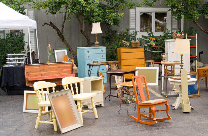 Furniture items set up in driveway for a garage sale.
