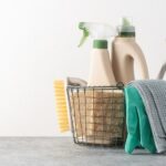 Basket of cleaning supplies on concrete floor.