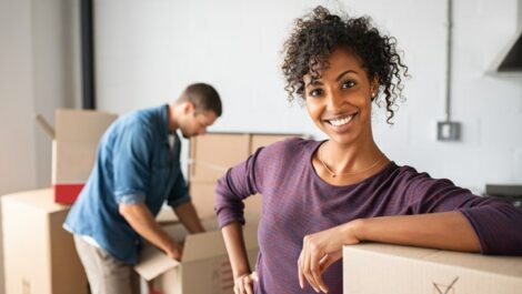 Woman smiling and leaning against a box