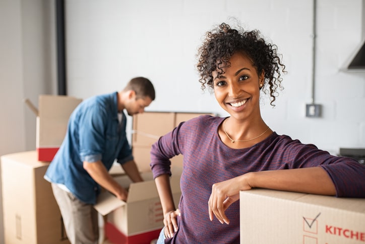 Woman smiling and leaning against a box
