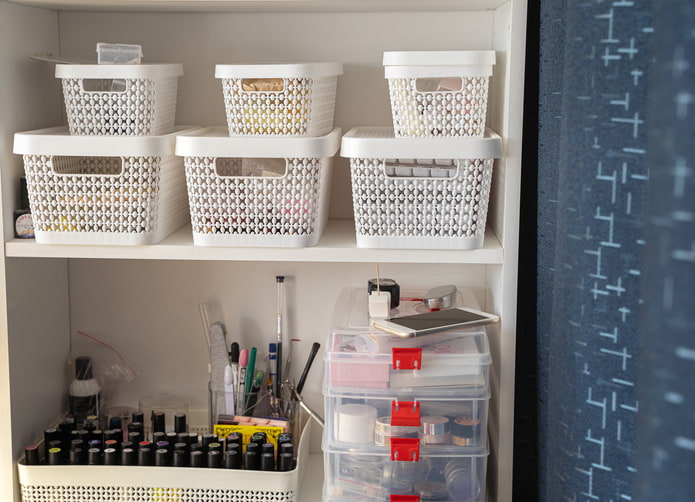 White storage totes and bins holding make up and nail polish.