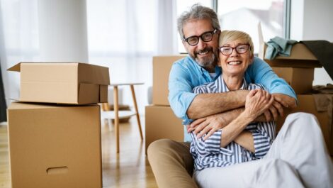 Mature couple hugging each other while sitting on the floor