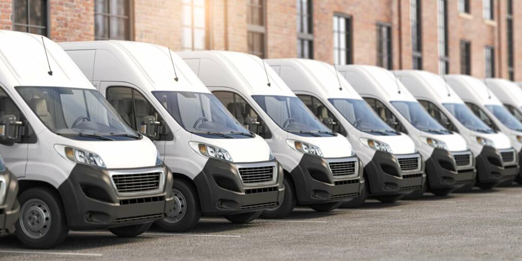 A fleet of white delivery vans parked neatly in a row