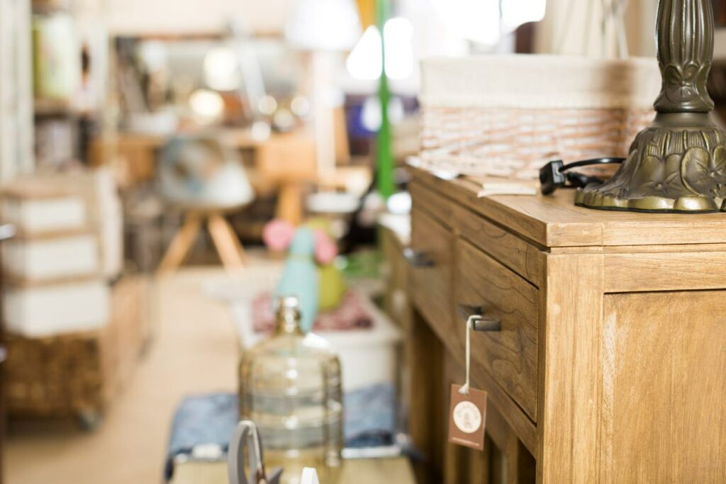 A store with an eclectic assortment of items, including a lamp sitting on a dresser.