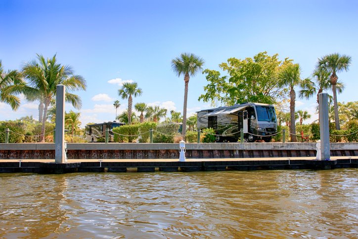RV with a peaceful waterfront view in Everglades City, Florida, USA. Palm trees and clear skies complete the serene scene