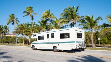 An RV on the road in Key West, with palm trees in the background