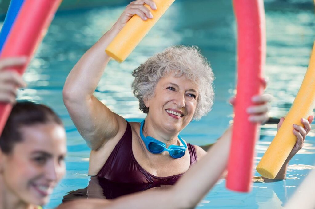 Close-up shot of elderly woman enjoying pool exercises. 