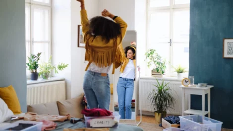 Woman dancing in the mirror while organizing her closet.
