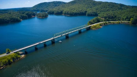 An aerial photograph of a blue lake with a bridge running through the middle