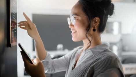 Woman using smart home hub on wall